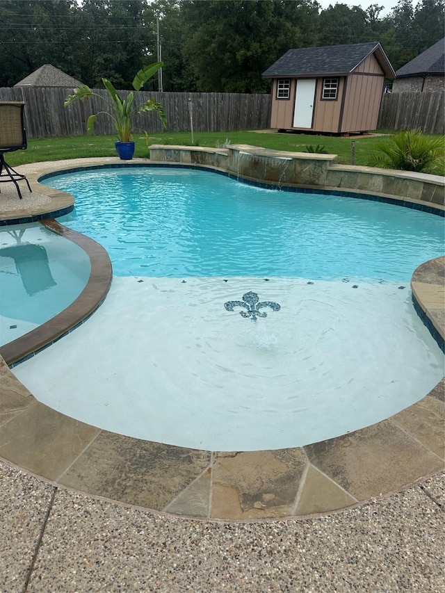 view of swimming pool featuring pool water feature and a shed