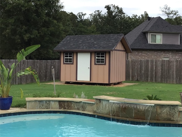 view of pool with a yard, pool water feature, and a shed