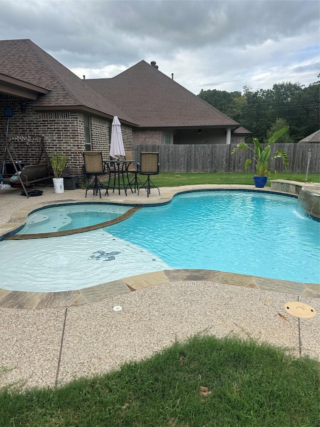 view of swimming pool featuring pool water feature and a patio area