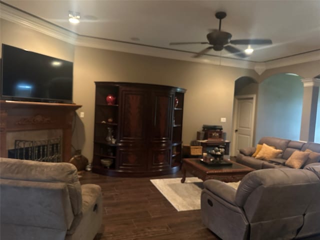 living room with decorative columns, ceiling fan, crown molding, and dark hardwood / wood-style floors