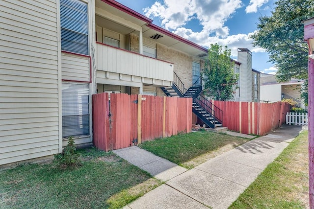 view of side of property with stairway and fence