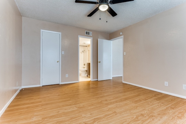 unfurnished bedroom featuring a textured ceiling, ceiling fan, ensuite bath, and light hardwood / wood-style floors