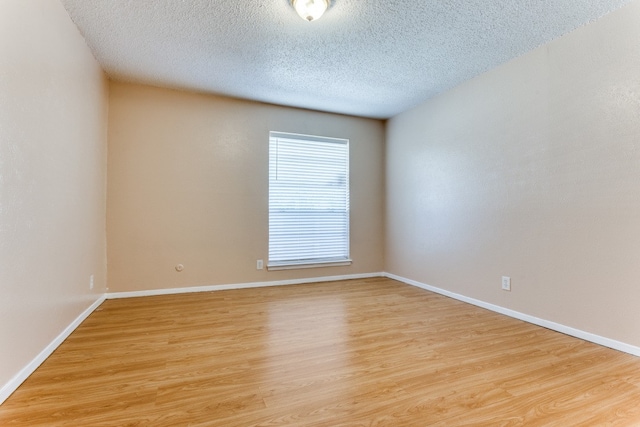 empty room featuring light hardwood / wood-style floors and a textured ceiling