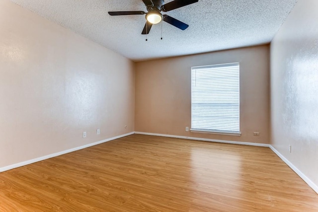 unfurnished room featuring light wood-style flooring, a ceiling fan, baseboards, and a textured ceiling