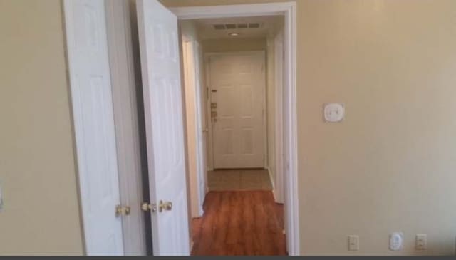 corridor with hardwood / wood-style flooring