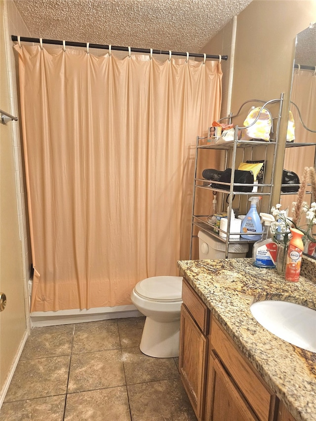 bathroom featuring vanity, a textured ceiling, toilet, and curtained shower