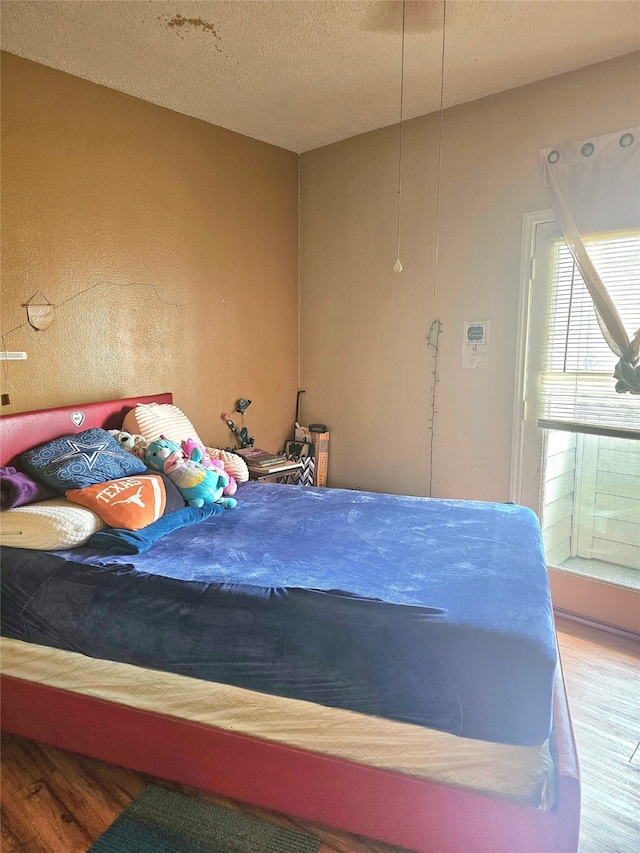 bedroom featuring a textured ceiling and hardwood / wood-style floors