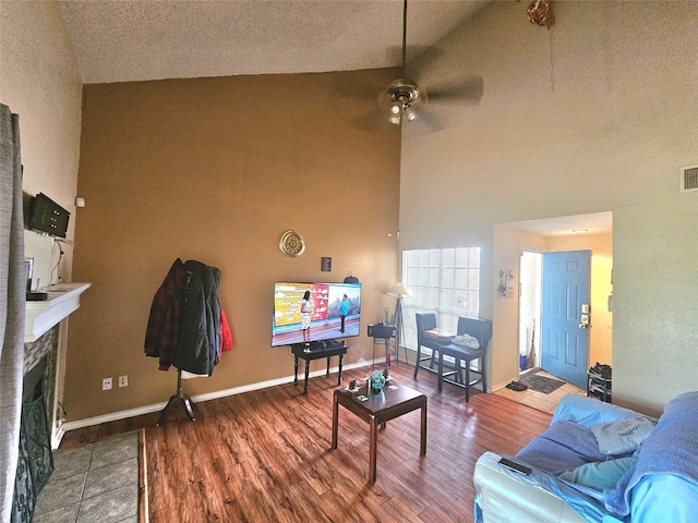 living room with ceiling fan, hardwood / wood-style floors, and high vaulted ceiling