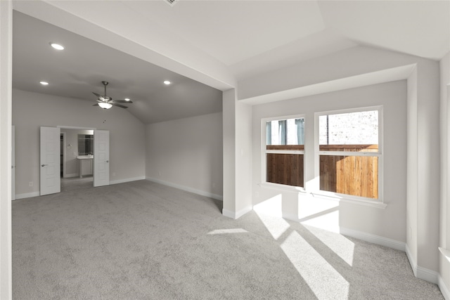 spare room featuring lofted ceiling, light colored carpet, and ceiling fan