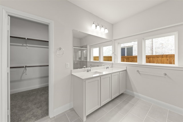 bathroom featuring tile patterned flooring, vanity, and a shower with shower door