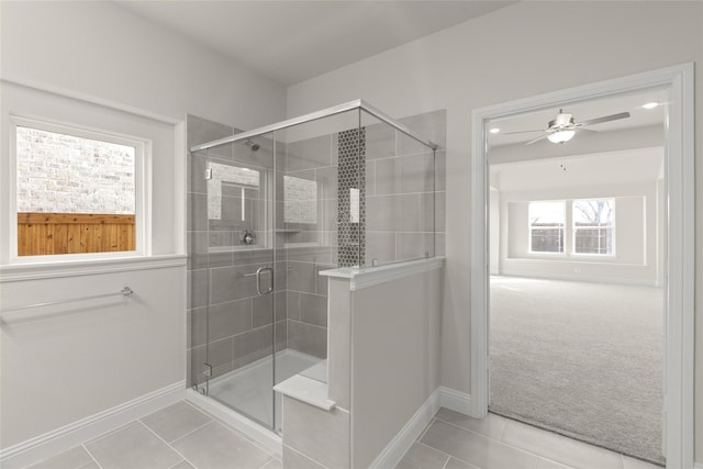 bathroom featuring a shower with door, tile patterned floors, and ceiling fan