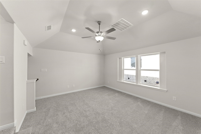 carpeted empty room with vaulted ceiling and ceiling fan