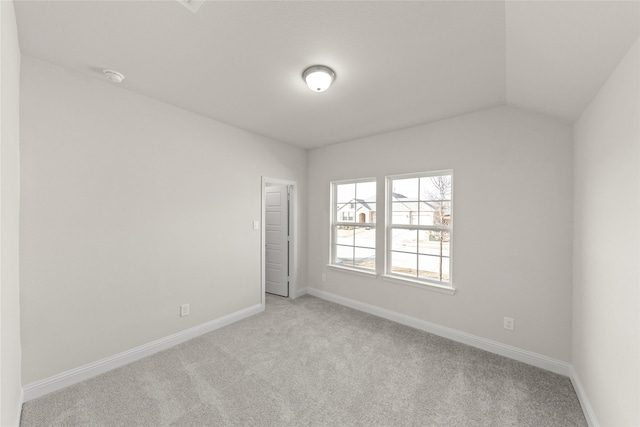 empty room with lofted ceiling and light colored carpet