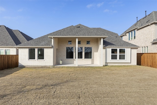 rear view of property featuring a patio area and a lawn