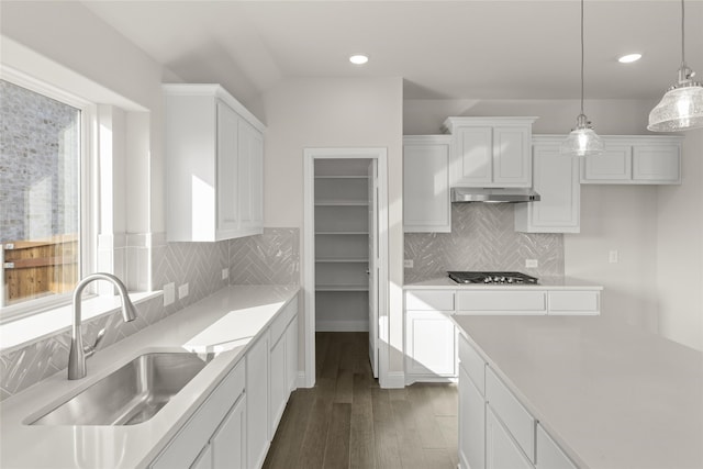 kitchen featuring sink, white cabinetry, dark hardwood / wood-style flooring, pendant lighting, and stainless steel gas stovetop