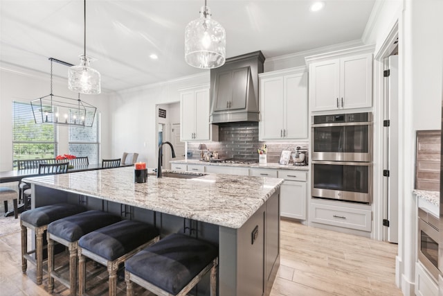 kitchen featuring a sink, decorative backsplash, custom range hood, appliances with stainless steel finishes, and crown molding