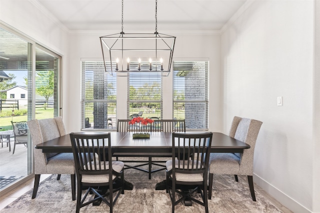 dining room featuring baseboards, plenty of natural light, an inviting chandelier, and ornamental molding