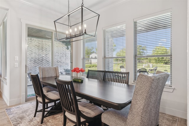 dining space featuring a chandelier, ornamental molding, and light wood finished floors