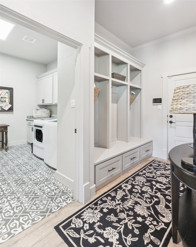 mudroom featuring wood finished floors, visible vents, baseboards, washing machine and clothes dryer, and crown molding