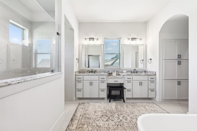 bathroom with tile patterned flooring, a freestanding bath, vanity, and a walk in shower