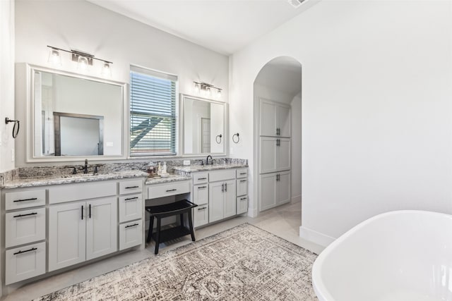 bathroom with vanity, a soaking tub, visible vents, and tile patterned floors