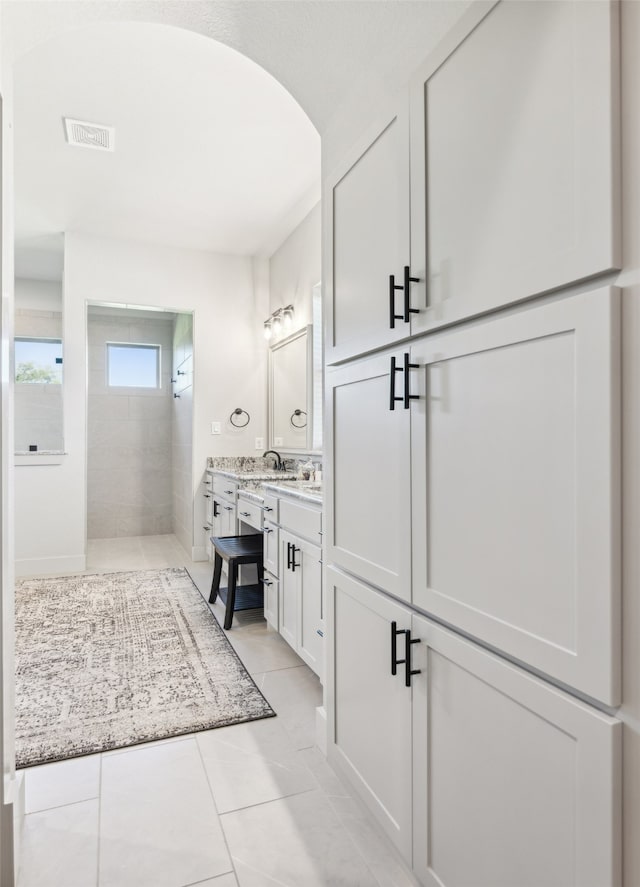 full bathroom with tile patterned floors, visible vents, vanity, and a walk in shower