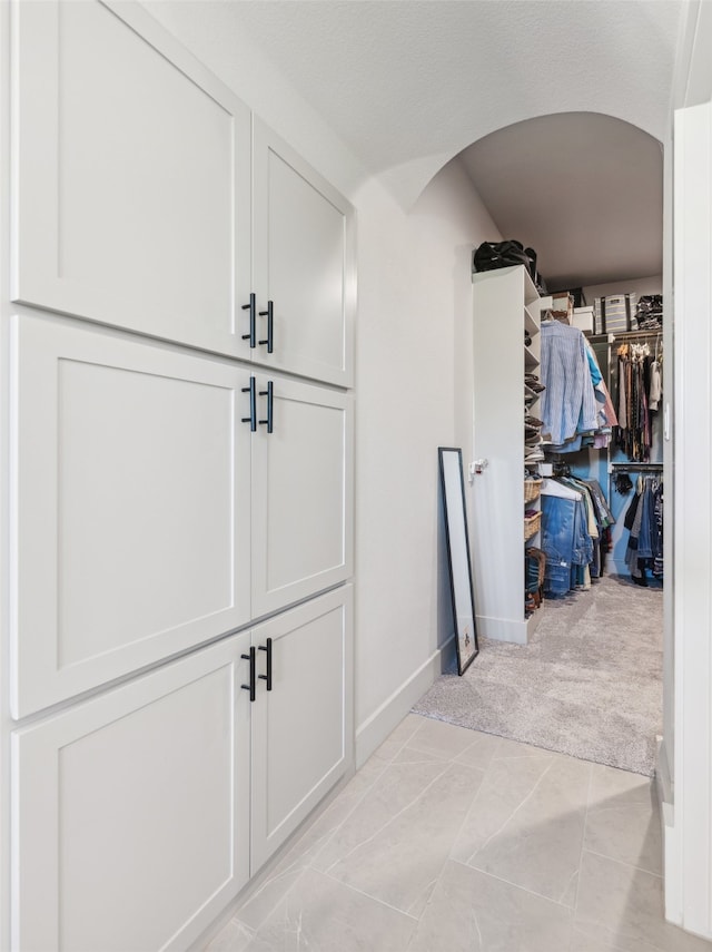 interior space with baseboards and light colored carpet