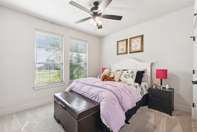 carpeted bedroom featuring baseboards and a ceiling fan