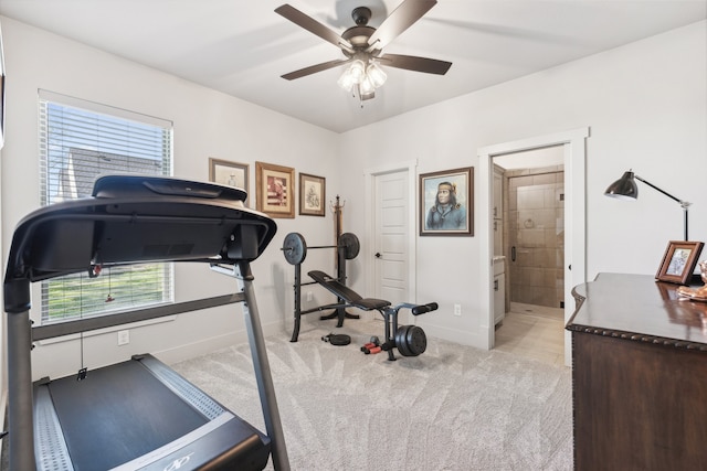 exercise area featuring baseboards, light colored carpet, and ceiling fan