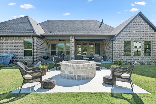 back of house featuring brick siding, a lawn, and a patio