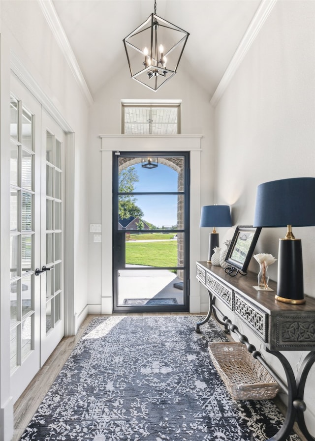 foyer featuring wood finished floors, french doors, and ornamental molding