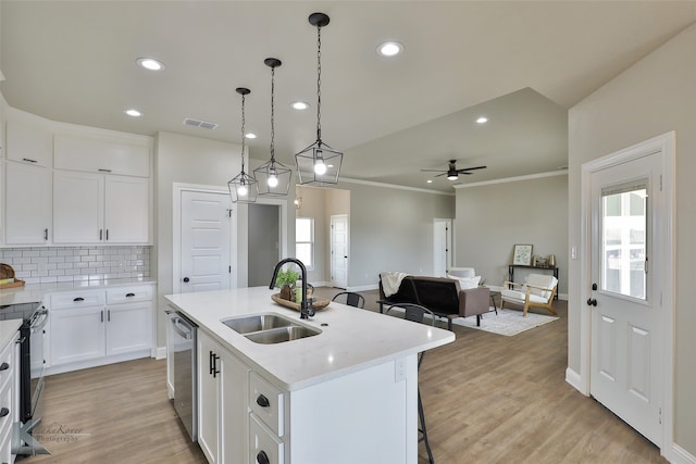 kitchen featuring hanging light fixtures, an island with sink, ceiling fan, sink, and white cabinets