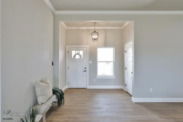 entryway featuring crown molding, a notable chandelier, and light hardwood / wood-style floors