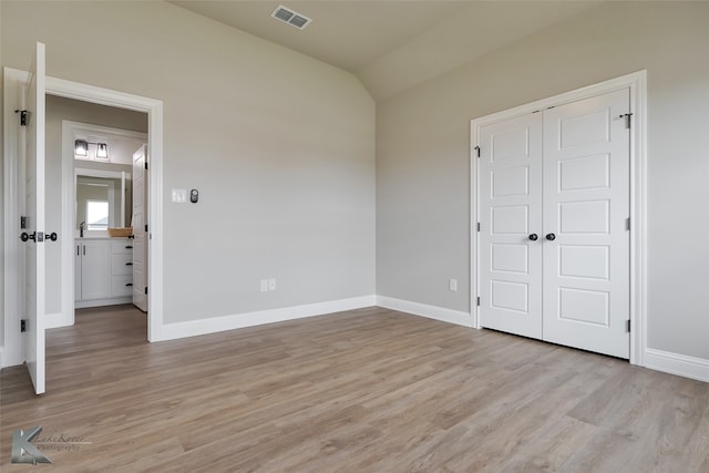 empty room featuring vaulted ceiling and light hardwood / wood-style flooring