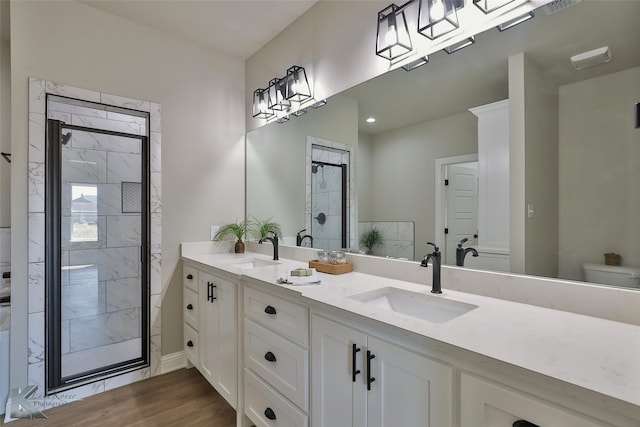 bathroom with vanity, toilet, hardwood / wood-style floors, and a shower with shower door