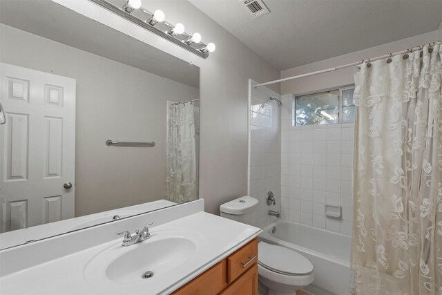 full bathroom featuring shower / bath combo with shower curtain, toilet, and vanity