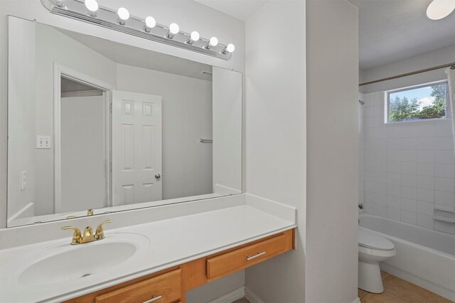 full bathroom with tile patterned flooring, toilet, tiled shower / bath combo, and vanity