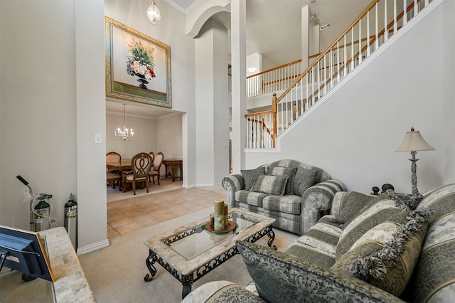 living room featuring crown molding, a towering ceiling, tile patterned floors, and a chandelier