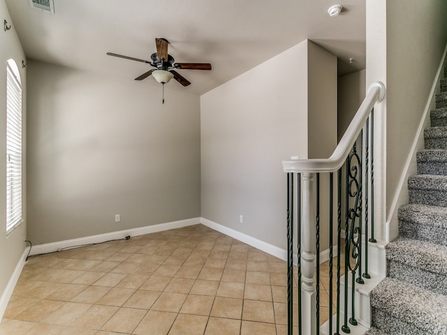 tiled empty room featuring ceiling fan and a textured ceiling