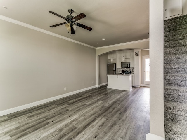 unfurnished living room with ceiling fan, wood-type flooring, and ornamental molding