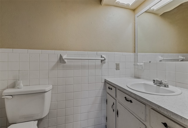 bathroom with tile walls, toilet, decorative backsplash, and vanity