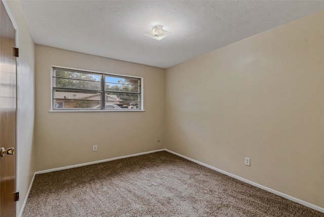 carpeted empty room featuring a textured ceiling