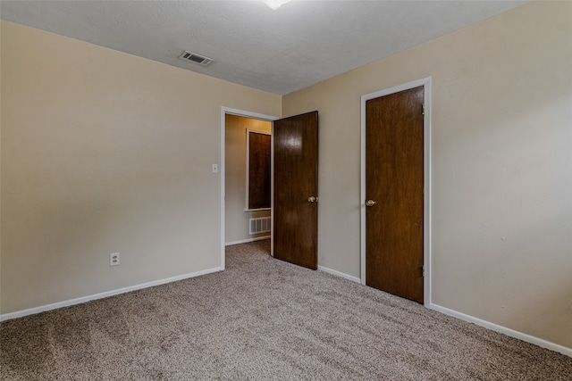 unfurnished bedroom featuring a textured ceiling and carpet flooring