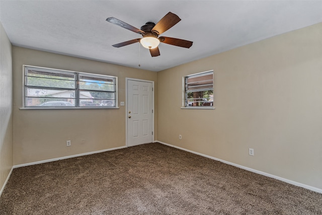 carpeted spare room with a wealth of natural light and ceiling fan