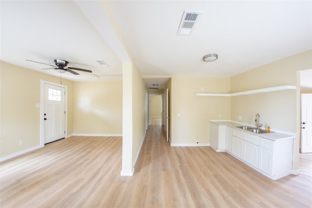 empty room featuring light hardwood / wood-style flooring, ceiling fan, and sink