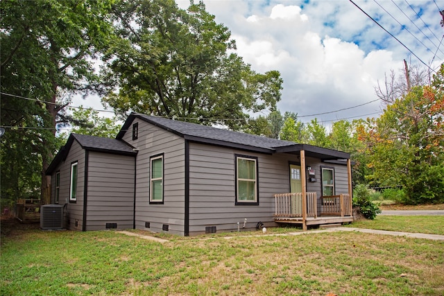 view of front of property featuring cooling unit, a front lawn, and a deck