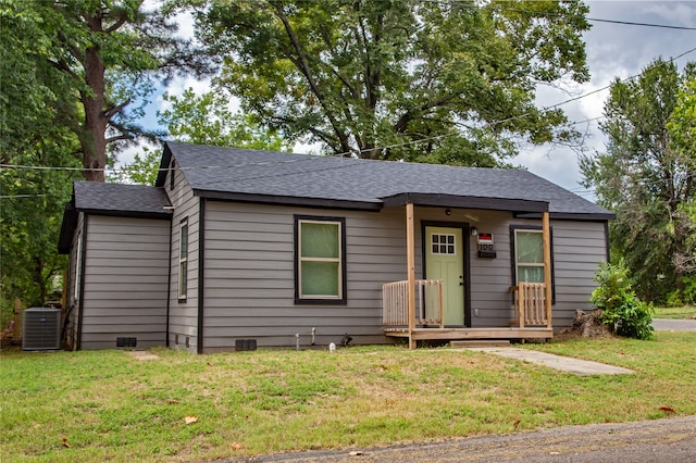 view of front of house with a front lawn and central AC