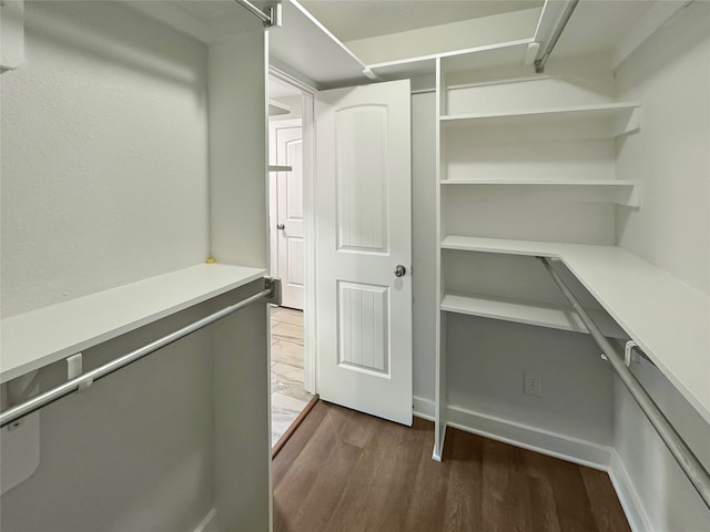 spacious closet with dark hardwood / wood-style floors