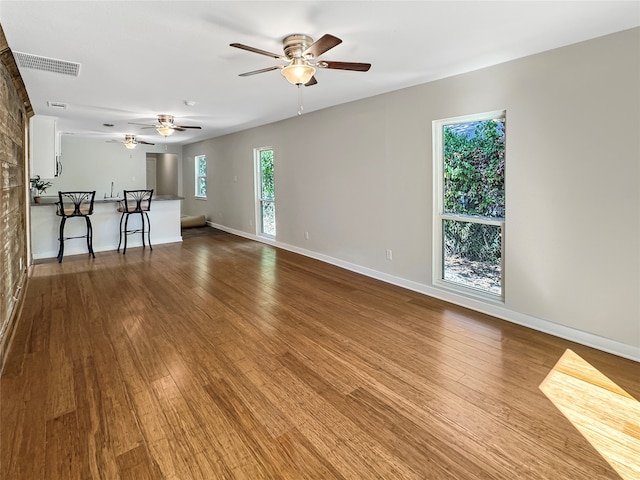 unfurnished living room featuring ceiling fan and hardwood / wood-style floors