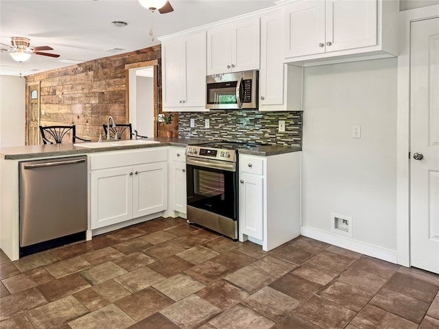 kitchen with ceiling fan, sink, tasteful backsplash, white cabinetry, and stainless steel appliances